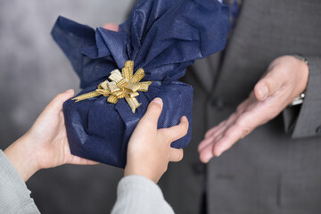 父親にプレゼントを渡す子どものクローズアップ