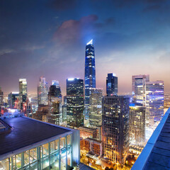 Fantastic rooftop view of city modern architecture by night with illuminated skyscrapers