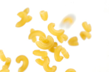 Macaroni flying explosion, yellow macaronis pasta float explode, abstract cloud fly. Curved macaroni pasta splash throwing in Air. White background Isolated freeze motion selective focus