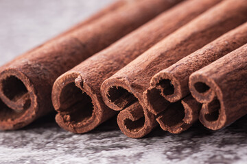 fragrant cinnamon sticks on a brown-gray background, photographed in close-up