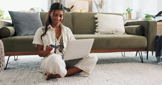 Happy woman, laptop and credit card on floor for payment, online shopping or transaction in living room at home. Female person or shopper smile on computer with debit in purchase, buying or ecommerce