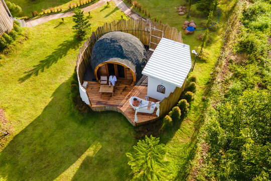 a couple of men and women camping in the mountains of Northern Thailand during vacation. Outdoor bathroom, and bathtub during sunset in the mountains at an igloo hut