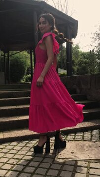 Beauty and charm: beautiful latino brunette model with a colorful fashion look in a park making poses and movements in a video and photo shoot