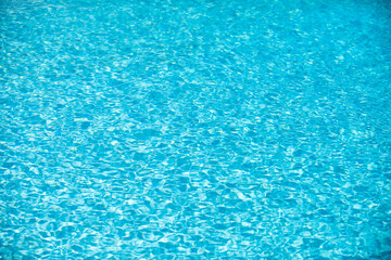 Water background, ripple waves. Blue swiming pool pattern. Sea surface. Water in swimming pool with sun reflection. Banner with copy space.