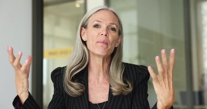 Confident mature businesslady makes speech, talk to client, calling by business use videoconference application. E-coach share knowledge, take part in professional webinar, head shot webcam portrait