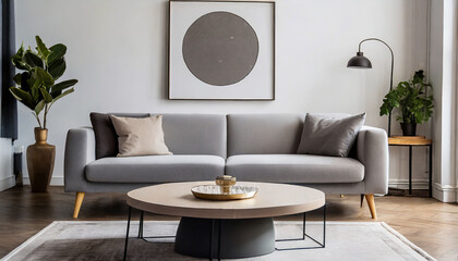 Round coffee table near grey sofa against white wall with art frame. Scandinavian home interior design of modern living room