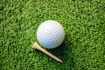 Golf balls and tees are placed on artificial grass.