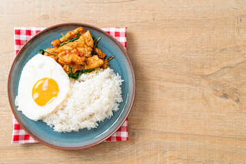 stir-fried fried fish with basil and fried egg topped on rice