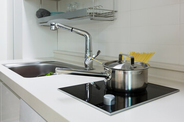 A modern kitchen interior design with with a sink and electric cooktop