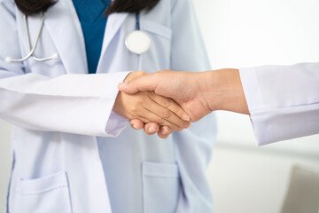 Close up, handshake and partnership in healthcare, medicine or trust for collaboration, unity or support at hosp. Medical team experts shaking hands in teamwork for agreement or success at hospital.