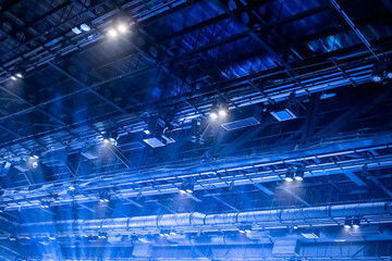 Blue light shines to the ceiling that is equipped with an air conditioning system, Wi-Fi devices,...