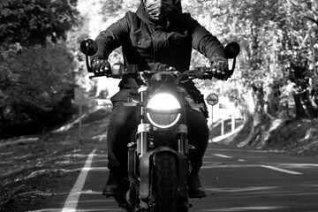 Fototapeta na wymiar motorcyclist riding on a country road, in an autumn landscape