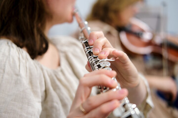 The flautist's hand, seen in macro view, gracefully glides along the flute's keys, producing...