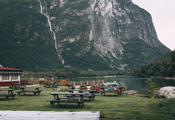 mountain lake with wooden tables and picnic benches in the mountains