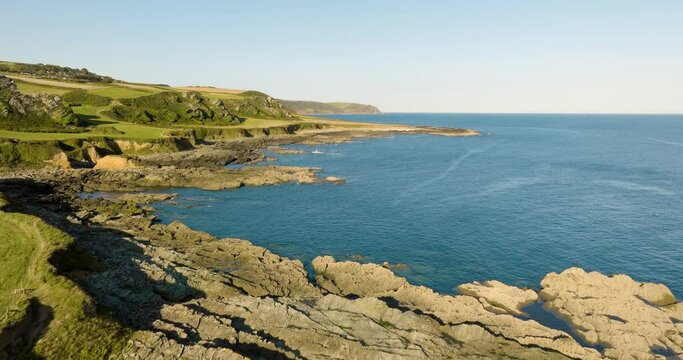 Rising Aerial Drone Shot Over Dramatic Devonshire Coastline Rocky Beaches Green Farmland And Clear Waters In Summer