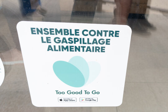Too Good To Go app logo brand and text french sign of Community of Waste Warriors fighting food waste together in phone app on shop door