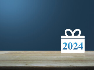 Gift box happy new year 2024 flat icon on wooden table over light blue wall, Business shop online concept