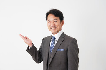 手のひらで左側を指す中年のビジネスマン　白背景