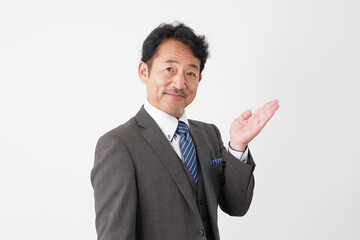 手のひらで右側を指す中年のビジネスマン　白背景
