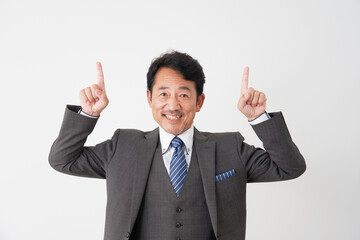 上方向を指差す中年のビジネスマン　白背景