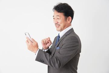 スマートフォンを使う中年のビジネスマン　白背景