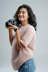 Young woman with professional camera isolated on background