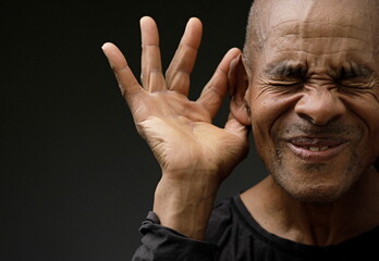 man suffering from deafness and hearing loss on grey background with people stock image stock photo	