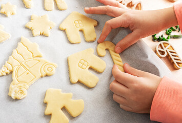 Children's hands with gingerbread cookies on wooden background