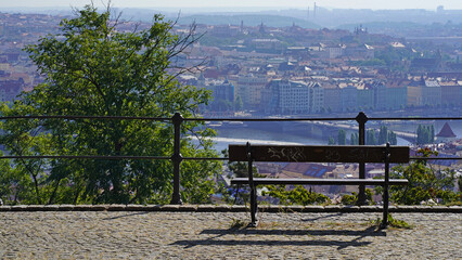 Obraz premium The capital of the Czech Republic is Prague. Beautiful panorama of the city. Panoramic view of Prague in a blue haze. Bench in a beautiful place from where you can see the city
