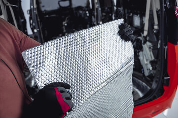 Tunning service worker install soundproofing material inside car interior