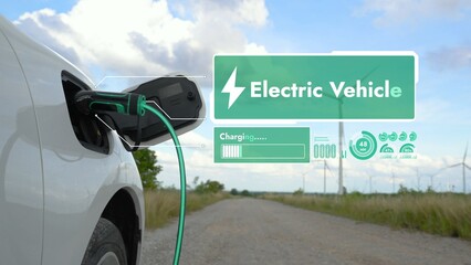 Electric car recharging energy from EV charging station display futuristic smart battery status hologram by EV charger plug cable in wind turbine farm. Alternative clean energy sustainability. Peruse