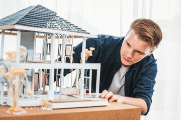Architect designer reviewing house frame model with no wall, brainstorming interior design and...