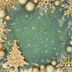 Christmas tree and gold bauble decorations on grunge green background. Abstract festive design for greeting card, invitation, Yule, Noel.
