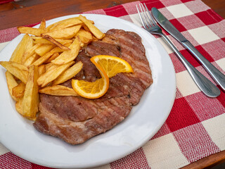grilled pork chops with french fries and orange slice