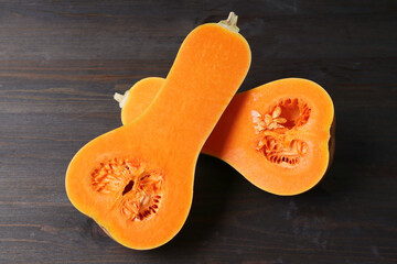 Ripe Butternut Squash Cut in Half Showing Vibrant Orange Flesh Isolated on Black Wooden Table