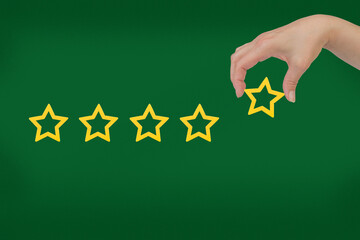 Woman's hand put the stars to complete five stars. Customer satisfaction concept. copy space and...