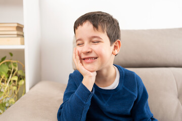 His minds in another place entirely. A little boy daydreaming at home