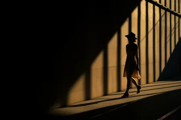 Fotobehang Woman walking in shadows in the city, dark light photography © alisaaa