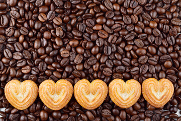 Top view of roasted coffee beans with heart shape biscuit