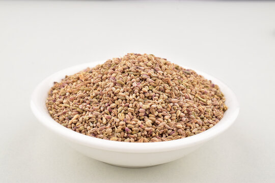 Closeup of carom seeds in bowl on white background