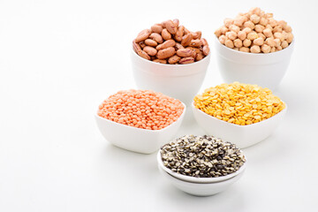 Variety of legumes and lentils in bowl on white background