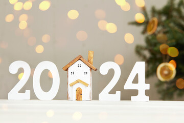 Happy New Year 2024 and Merry Christmas greeting card. Toy wooden house, white numbers 2024,...