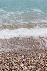 Clear water washing up on the shore at Paralia Ixia beach off Rhodes city creating a turquoise and brown gradient