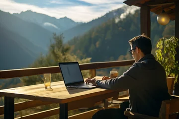 Tuinposter A man working comfortably on a laptop while enjoying a peaceful mountain view, showcasing the flexibility and choice of remote work environments © Mikhail