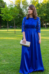 Cute teen girl with make up posing outdoor. Pretty female model in fashionable blue evening dress