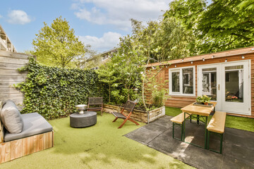 a backyard area with wooden furniture and an outdoor fire pit in the space is surrounded by lush...