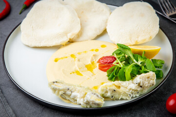 fish steak with rice cakes, cherry tomatoes, lemon and herbs, side view