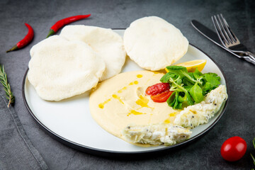 fish steak with rice cakes, cherry tomatoes, lemon and herbs, side view
