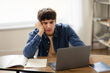 Unhappy overworked arabian businessman sitting sad at workplace