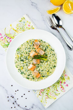 rice porridge with greens, artichoke and pieces of red fish, top view